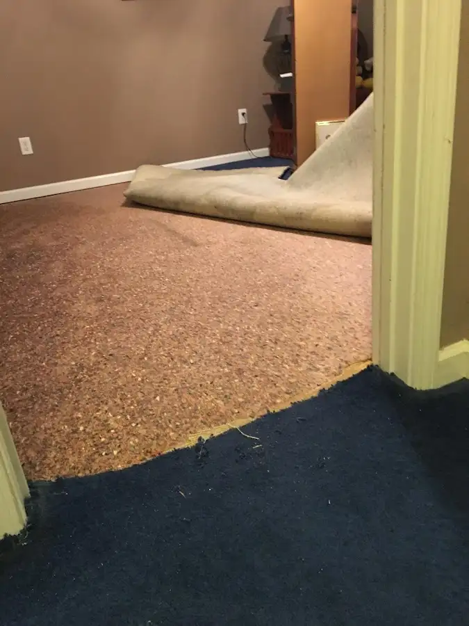 Carpet pad removal revealing water damage during Water Mitigation Services in White Hall